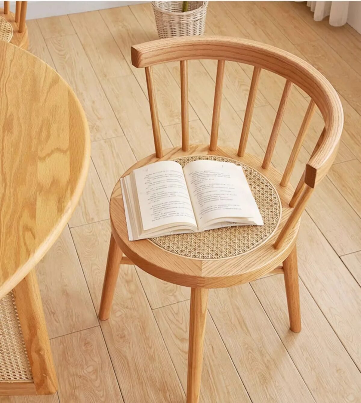 Luxury solid rubber wood and natural rattan round back dining chair with handwoven cane seat in Scandinavian coastal modern dining room interior.