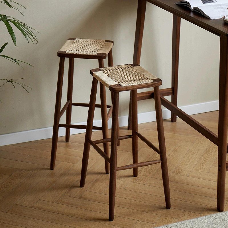 Backless counter stool featuring a North American SUP-grade solid wood frame and a hand-woven double-sided rope rattan seat. Shown with traditional mortise and tenon joinery, sturdy tapered legs, and a built-in footrest. Available in Walnut and Cherry finishes.