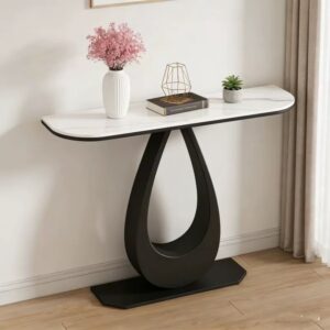 Contemporary console table with a Snow Mountain White sintered stone top and a matte black metal frame, styled in a minimalist hallway with a pink flower vase.