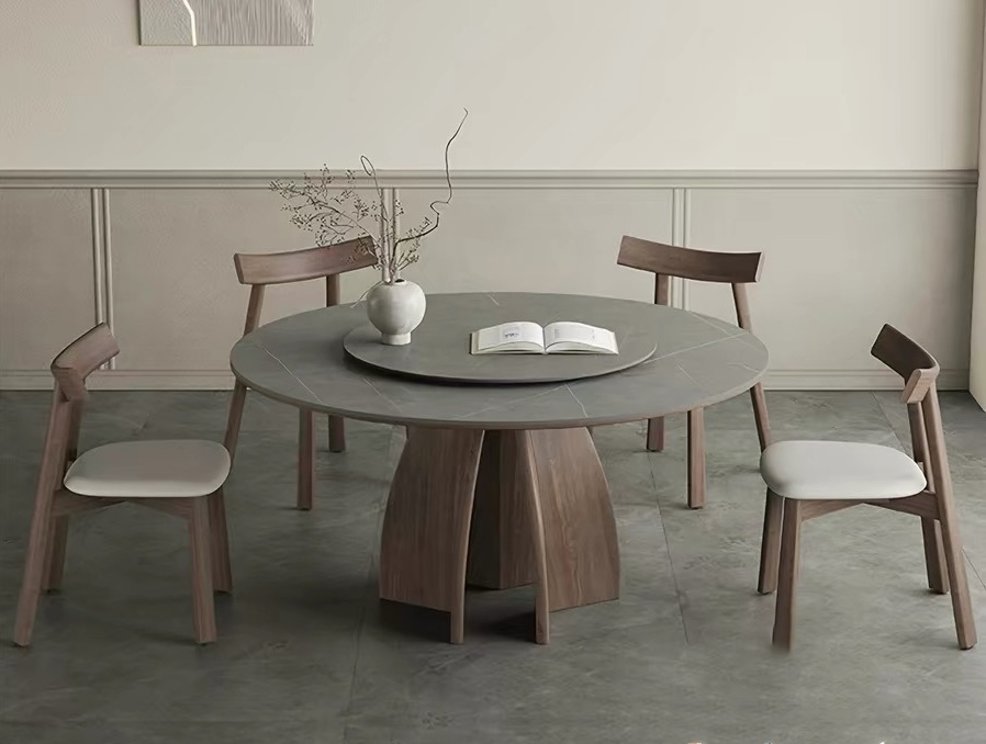 High-angle overhead view of a premium circle dining room table set with an integrated rotating center turntable (Lazy Susan), showcasing the durable gray matte sintered stone surface, dark wood pedestal frame, and four elegant matching dining chairs.