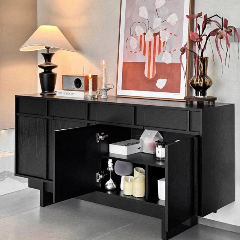 Fully assembled black wooden dining room sideboard with doors open showing spacious interior shelves organized with candles and decor items.