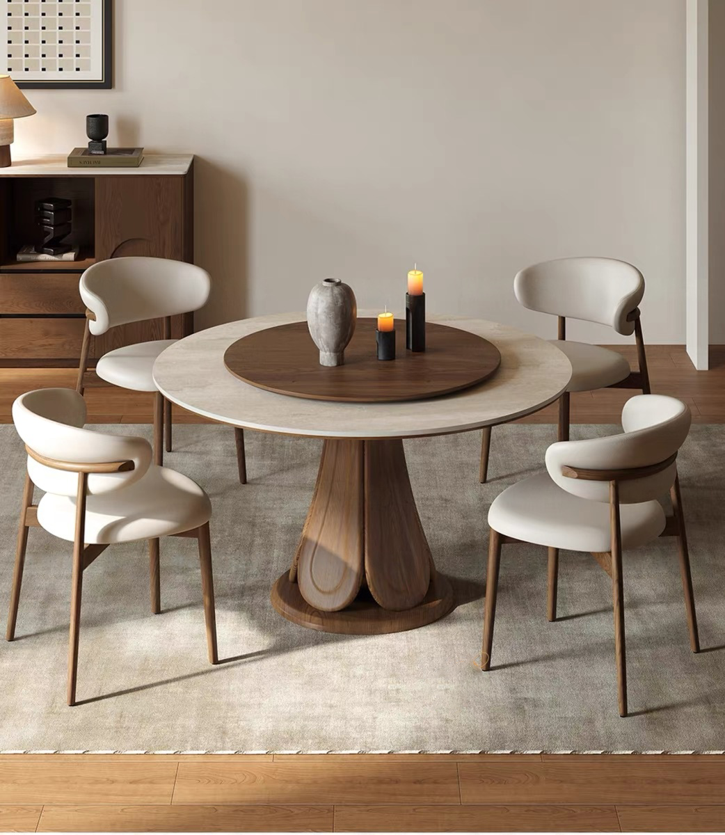 A complete 5-piece luxury dining room set showcasing the designer round pedestal dining table with a sintered stone tabletop and integrated rotating wooden center turntable. Four contemporary cream leather upholstered chairs with bentwood backing surround the table in a minimalist, warm-toned dining room.