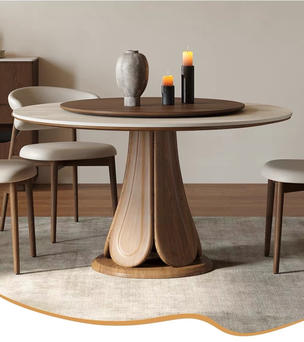 Luxury round dining table featuring a white sintered stone top with a dark walnut-stained wood Lazy Susan turntable. The table is supported by an architectural fluted pedestal base made of premium solid FAS ash wood, set on a plush grey area rug with modern cream leather dining chairs.
