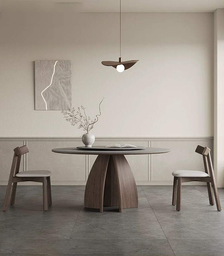 Modern luxury round dining table featuring a matte gray sintered stone top and a sculpted dark brown pedestal base made of premium North American white ash wood.