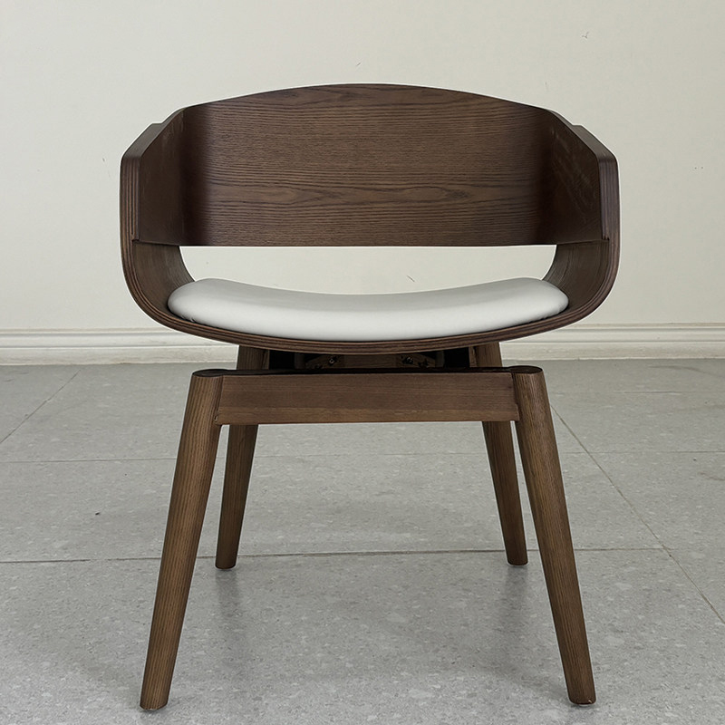 Modern designer walnut bentwood dining chair with curved wooden armrests, leather upholstered seat and solid wood legs.