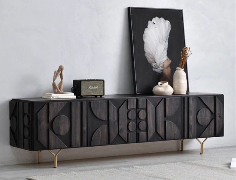 Living Well ZA solid wood black TV unit featuring carved geometric door panels and gold Y-shaped metal legs.