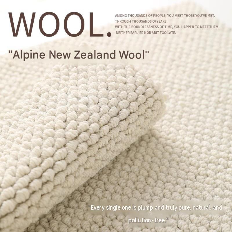 Close-up texture of plush hazelnut-patterned loop pile made from natural off-white Alpine New Zealand wool.