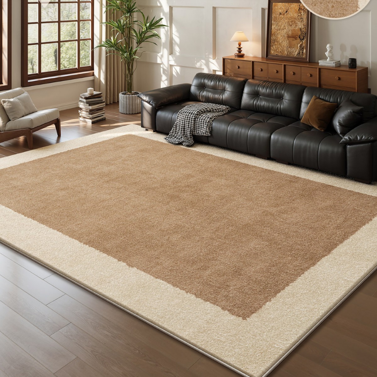 Modern luxury beige and brown area rug with a dark border placed on a hardwood floor in a stylish living room setting